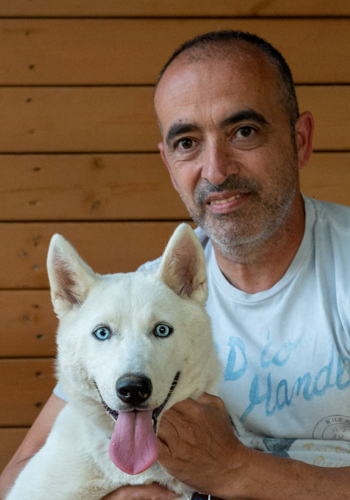 Home i gos husky amb ulls blaus.