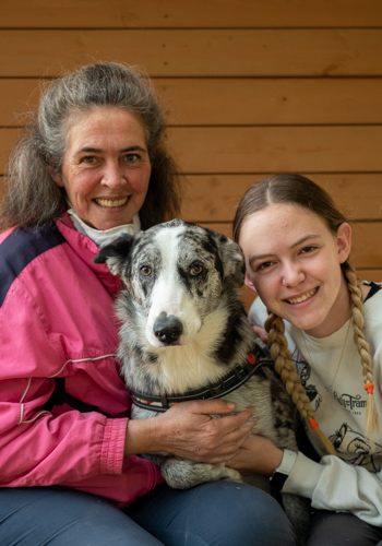 Dues dones i un gos somrient a càmera.