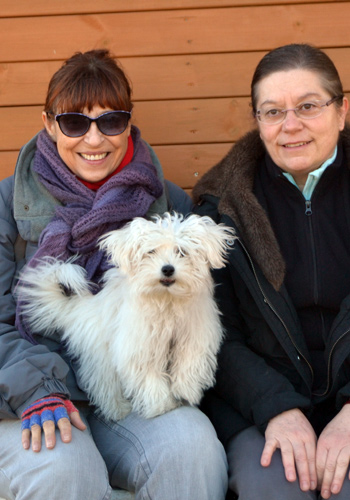 Dues dones i un gos asseguts junts.