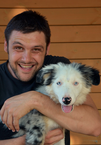 Home somrient amb el seu gos de raça Border Collie.