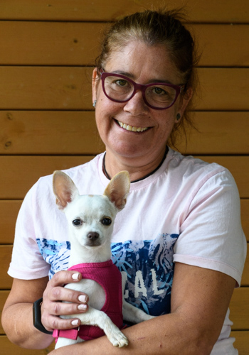 Dona somrient amb un gos Chihuahua.