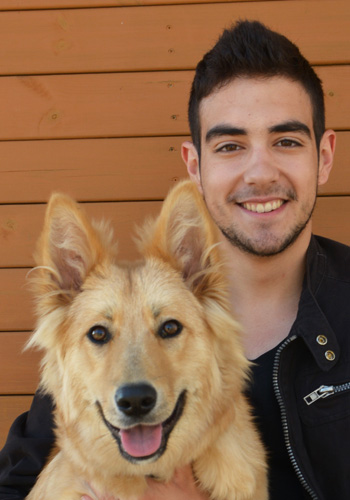 Home jove amb gos pelut somrient.
