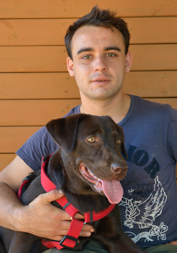 Home jove amb gos de color marró.