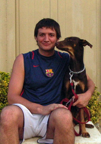 Home assegut amb gos i samarreta del Barça.