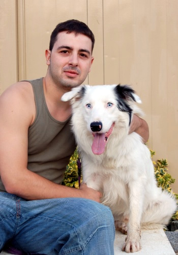 Home amb gos de pèl blanc i ulls dispars.
