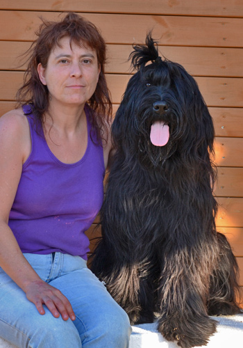 Dona amb gos de pèl llarg negre.