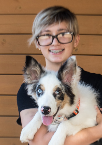 Noia somrient amb gos de raça Border Collie.