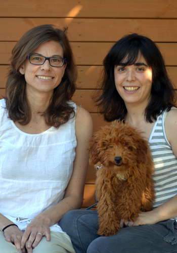Dues dones somrients amb un gosset marró.