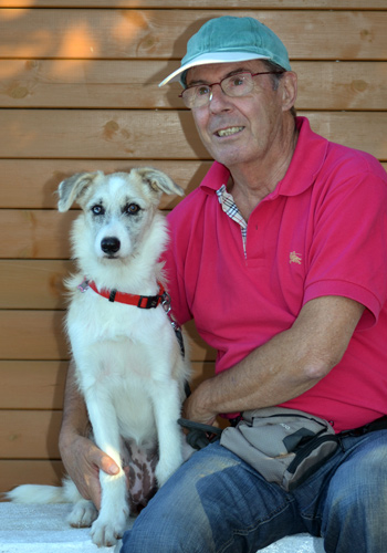 Home assegut amb el seu gos en un banc de fusta.