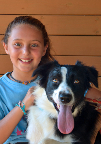 Noia somrient amb gos border collie.