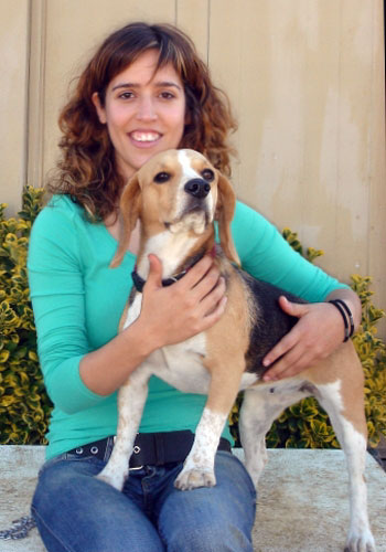 Dona somrient amb un gos beagle.