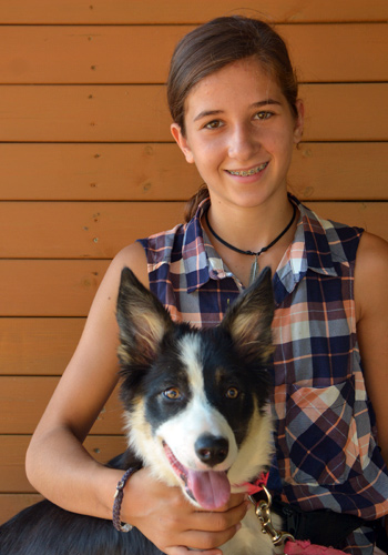 Noia amb gos Border Collie somrient.