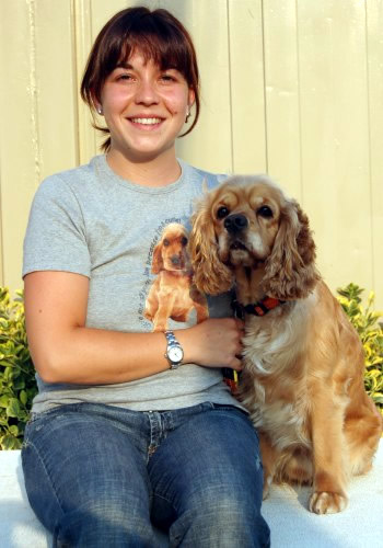 Dona somrient amb un gos cocker spaniel.