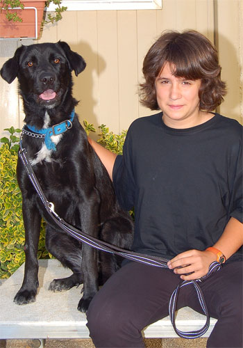 Noi amb el seu gos negre, corretja blava.