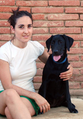 Dona amb un gos labrador negre.