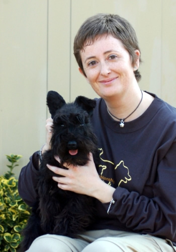 Dona amb un gos terrier negre.