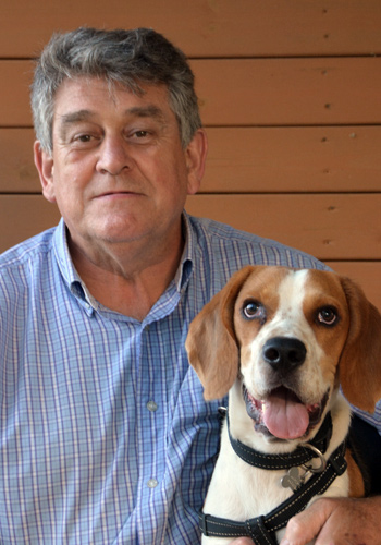 Home amb el seu gos beagle somrient.